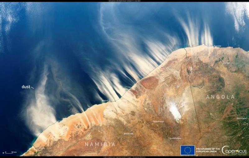 A high-resolution satellite image captured by Copernicus Sentinel-3 showing massive light-brown dust plumes blowing from the Namib Desert across the coastline of Namibia and Angola into the deep blue Atlantic Ocean